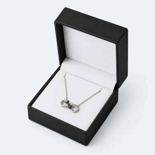 Open black and white PU leather necklace box with silver necklace displayed inside