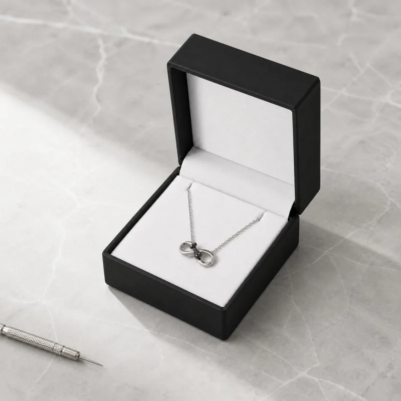 Black and white PU leather necklace box with silver necklace in a retail presentation scene