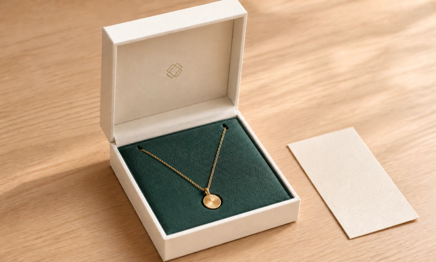Open hinged necklace box with the chain secured in two insert slots and the pendant lying flat.